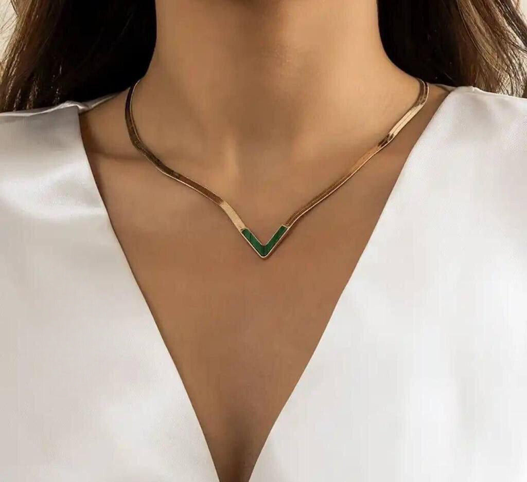 Stainless necklace featuring a snake's back with a green letter V
